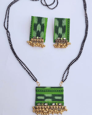 Green and gold necklace with matching earrings on a white background