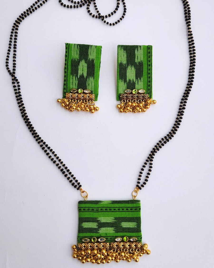 Green and gold necklace with matching earrings on a white background