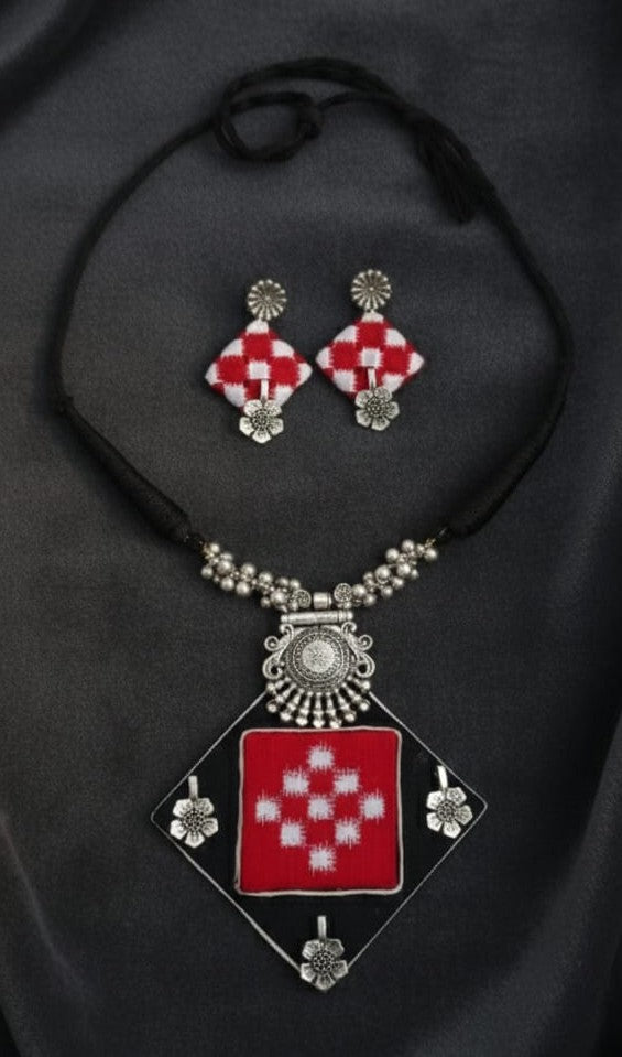 Necklace with geometric pendant and matching earrings on a white background