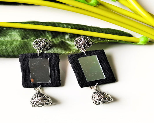 Pair of earrings with black square pendants and silver accents on a white background